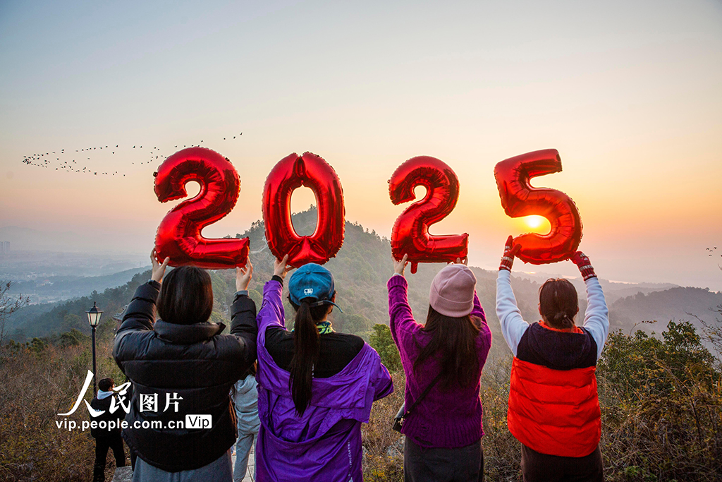 2025年1月1日，人們在江西省九江市都昌縣南山舉起“2025”字樣迎接新年第一縷陽光。傅建斌攝（人民圖片網(wǎng)）