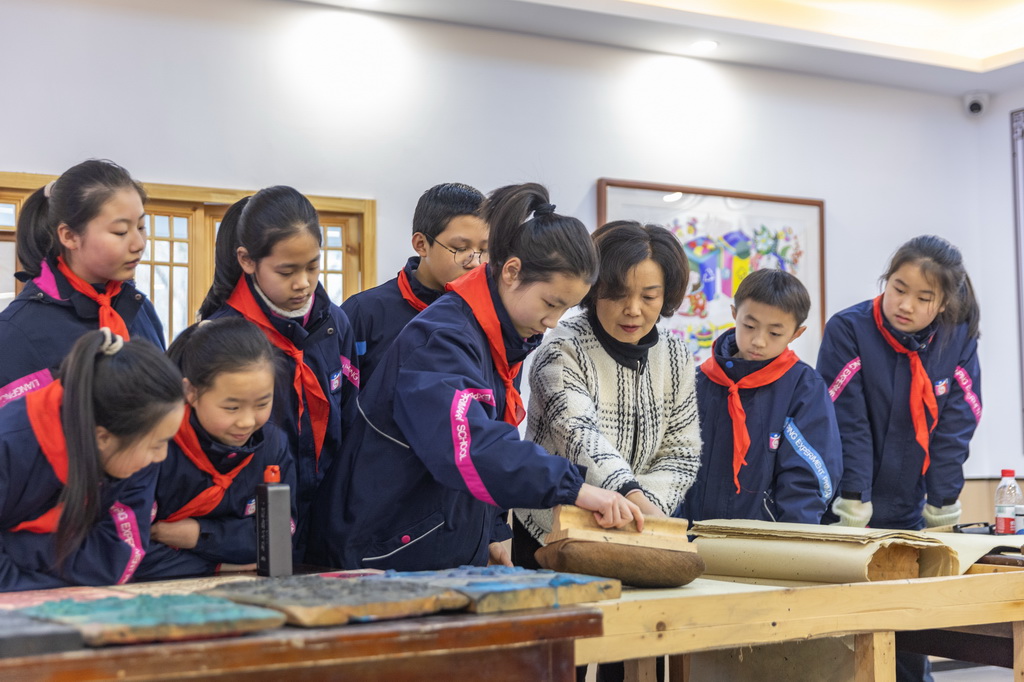 1月15日，在重慶市梁平區(qū)梁平實(shí)驗(yàn)小學(xué)少兒年畫館，梁平木版年畫市級(jí)代表性傳承人莫紹萍指導(dǎo)學(xué)生們學(xué)習(xí)梁平木版年畫的刷印。