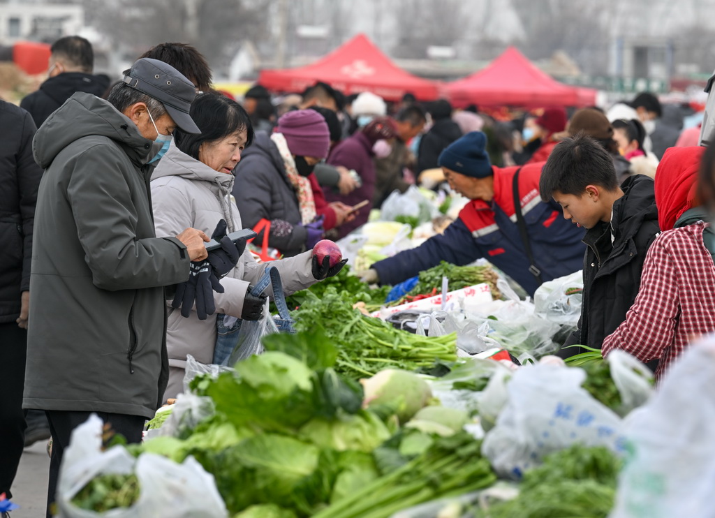 1月21日，人們在金貴集貿(mào)市場選購蔬菜。